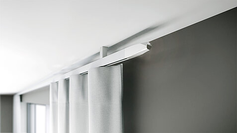MHZ Vorhangstange „Cube“ in Weiss, an der Decke montiert mit hellen Vorhängen in einem modernen Raum.