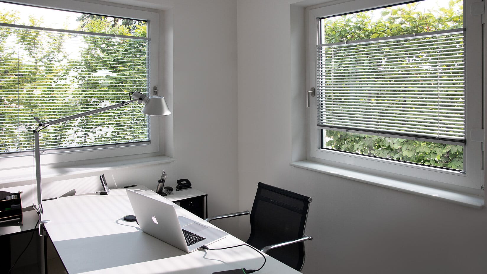 Blendschutz am Arbeitsplatz durch Jalousien am Fenster