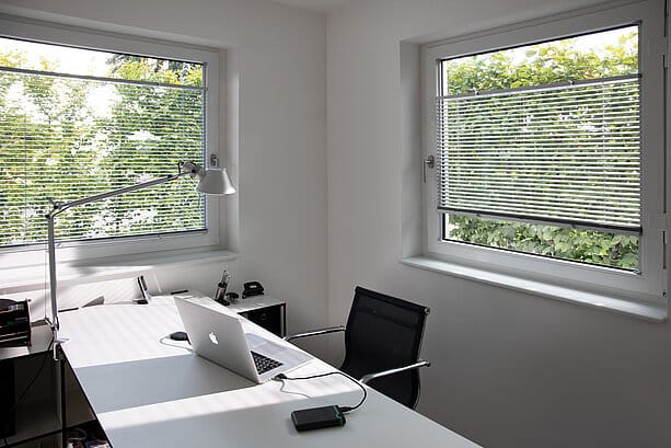 Blendschutz am Arbeitsplatz durch Jalousien am Fenster