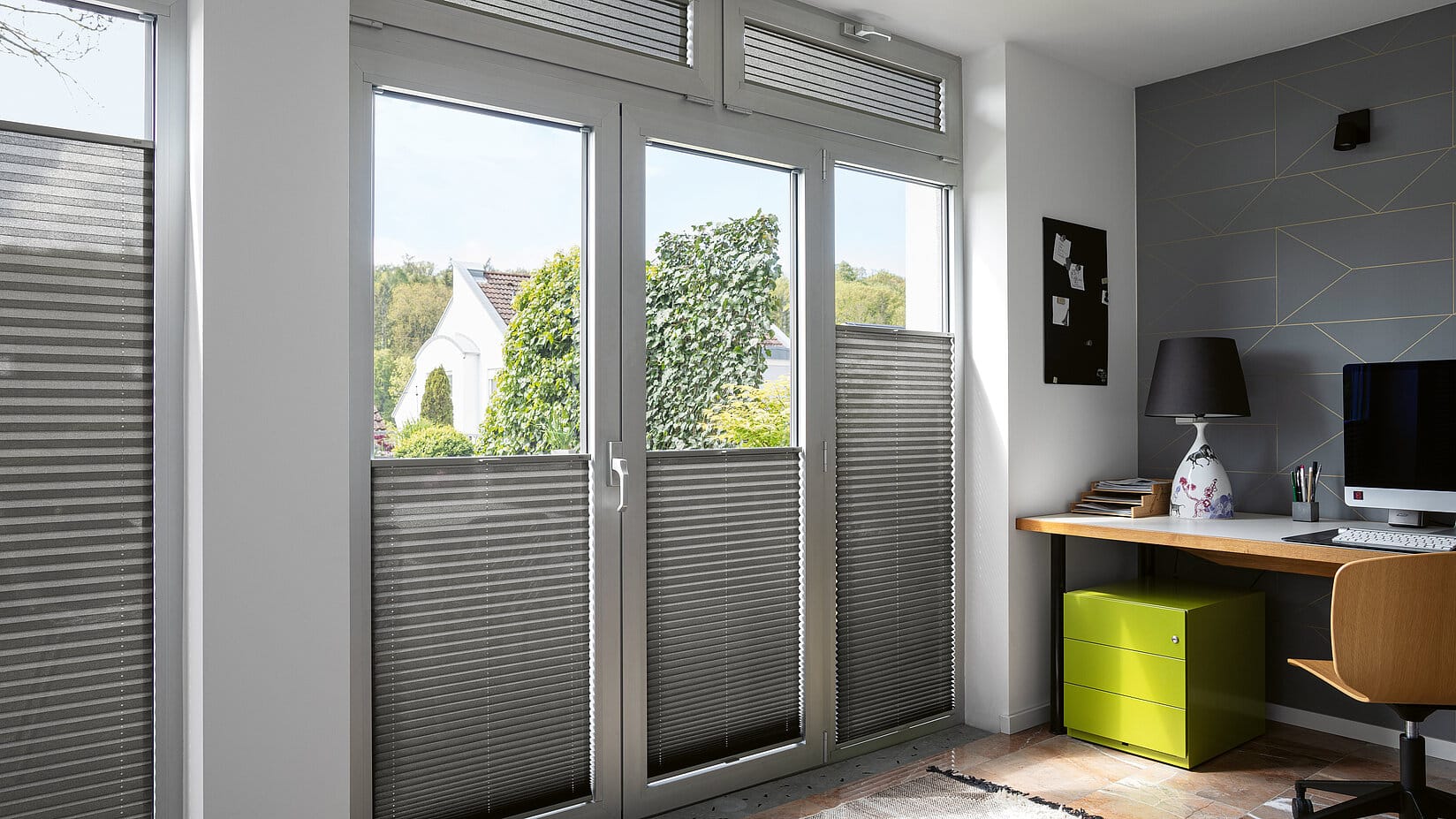 Blendschutz am Arbeitsplatz durch dunkles Plissees an Fenster und Türen