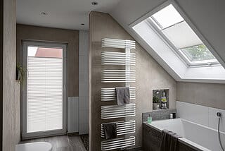 helle Plissees im Badezimmer an Dachfenster und Balkontür