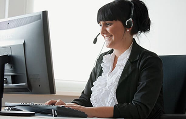 MHZ Servicemitarbeiterin am Computer und Telefon.
